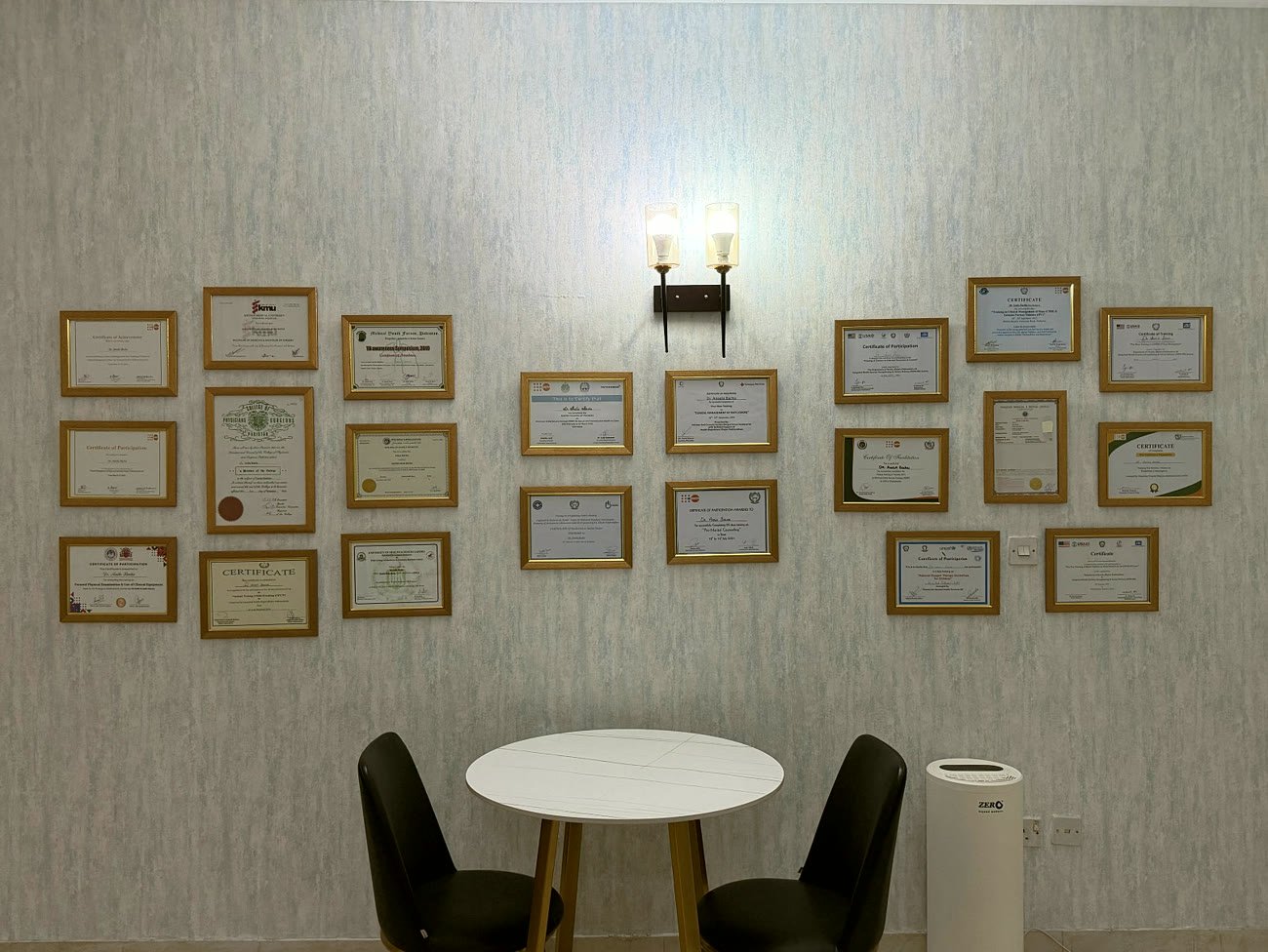 The wall of framed training certificates at the clinic